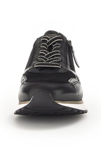 Schwarze Sneaker aus einer Kombination von glattem Leder und Wildleder, mit einem auffälligen Schnürdesign, einem äußeren Reißverschluss und einer strukturierten Sohle.