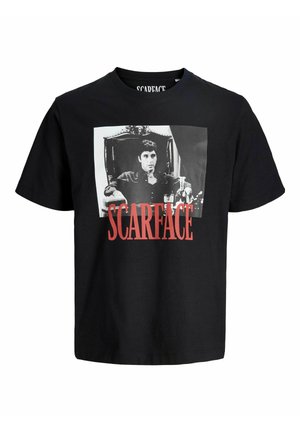 Črna bombažna majica z izstopajočo belo grafiko moškega na stolu. Beseda "SCARFACE" je natisnjena s poudarjeno rdečo barvo pod sliko.