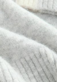 Light gray knit sweater fabric featuring a soft, fuzzy texture with ribbed patterns. The material appears warm and cozy.