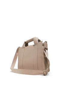 Beige texturerad handväska med dubbla topphandtag och en avtagbar axelrem, med dragkedjestängning och strukturerad form.