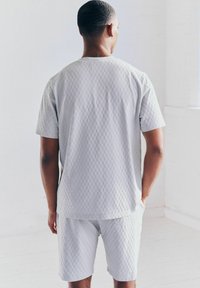 Gray textured short-sleeve shirt and shorts set with a diamond pattern, featuring a relaxed fit and side pockets, viewed from the back.
