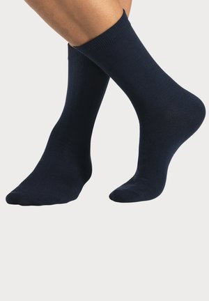 Marineblaue Baumwollsocken mit gerippten Bündchen, mittlerer Dicke und glatter Textur, die so gestaltet sind, dass sie eng um den Knöchel sitzen.