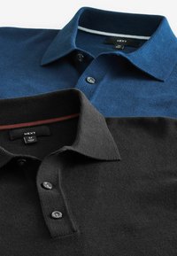 Zwei Poloshirts mit Kragen: eines in Dunkelblau mit strukturiertem Stoff und kontrastierendem Kragen, und eines in Schwarz mit sichtbaren Knöpfen.