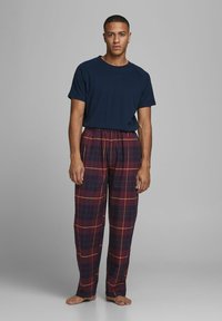 Camiseta de navy de manga corta combinada con pantalones de pijama a cuadros burdeos con líneas amarillas. Corte relajado y tejido ligero.