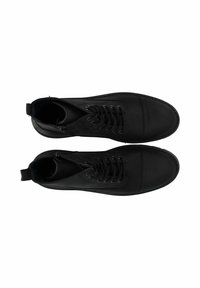Botas de tobillo negras con cordones, con un acabado suave, punta redondeada y suela plana. Incluyen cremallera y tira para facilitar su uso.