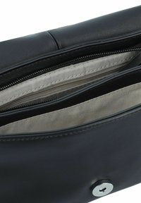Schwarze Lederhandtasche mit glatter Oberfläche, ausgestattet mit einem Reißverschlussfach und einem metallischen Druckknopfverschluss. Innen ist sie mit einem hellen Stoff gefüttert.