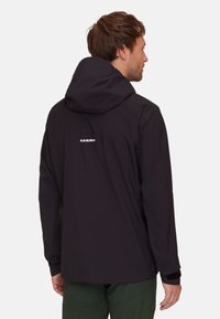 Black waterproof jacket with a hood, featuring a white logo on the back, long sleeves, and a smooth, lightweight texture.
