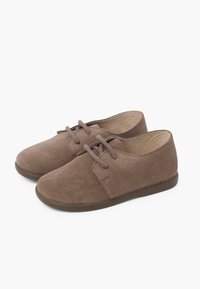 Scarpe in suede marrone con punta arrotondata, suola piatta e due fori per i lacci. Design semplice, texture morbida e dettagli minimal.