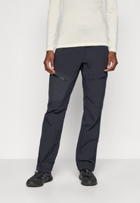 Pantalons d'extérieur navy avec deux poches zippées, une coupe fuselée et un tissu léger et durable. Le design comprend une taille élastique et des coutures renforcées.