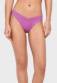 Parte inferior de bikini morado con un corte bajo, textura suave y diseño de cobertura mínima, con un frente en forma de V y líneas limpias.