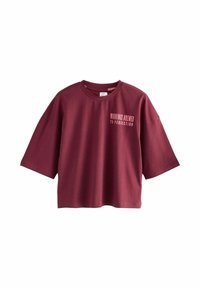 Burgundijas krāsas pārāk liels T-krekls, kas izgatavots no kokvilnas, ar īsām piedurknēm un noapaļotu kakla izgriezumu. Teksts priekšpusē lasa: “RĪTIENI, KAS SAGATAVOTI IDEĀLI.”