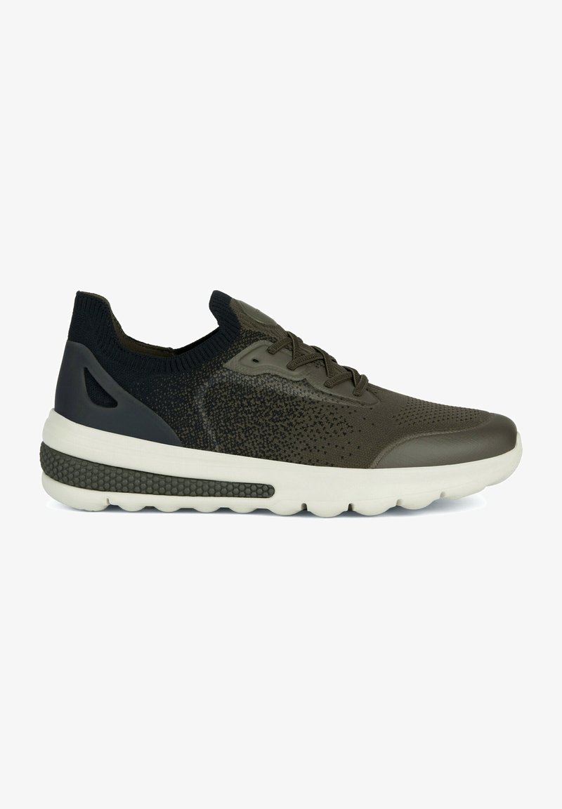 Zapatilla atlética verde oliva con un upper de punto texturizado, suela de goma y acentos oscuros en contraste. Cuenta con un collar tipo calcetín y un diseño ligero.