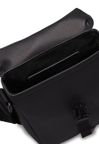 Bolso cruzado de cuero negro con una superficie texturizada, cierre magnético y un bolsillo interior. Cuenta con una correa ajustable resistente.
