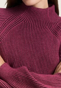 Gestrickter Pullover in kräftigem Magenta mit gestreiftem Muster und hohem Kragen. Verfügt über gerippte Akzente an den Bündchen und dem Saum.