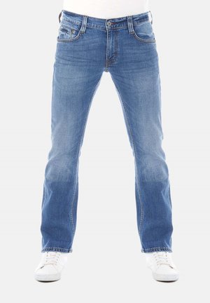 Jeans de mezclilla azul claro con corte recto, que cuentan con cinco bolsillos, cierre frontal con botón y un desgaste sutil en las piernas. Combinados con zapatillas blancas.