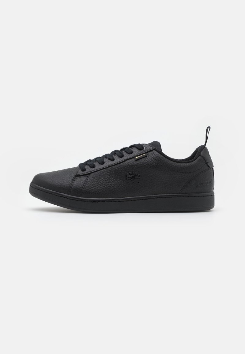 Basket en cuir noir à coupe basse avec lacets à l'avant et finition texturée, avec un petit logo sur le côté et une languette au talon.