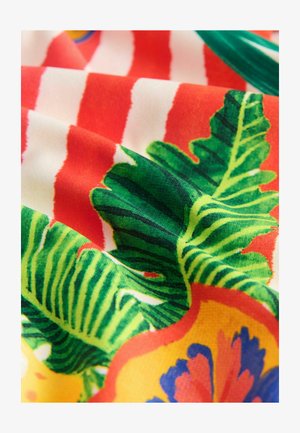 Tessuto multicolore con vivaci foglie verdi, brillanti motivi floreali gialli e rossi, e audaci strisce orizzontali rosse e bianche.