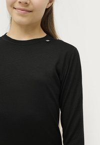 Zwart langemouwen shirt met een ronde hals, van textuurstof, met een klein zilveren logo accent nabij de schouder.