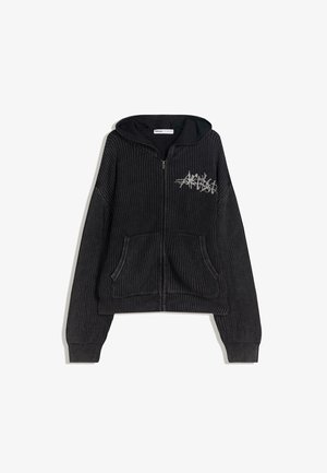 Musta neule vetoketjuhuppari, jossa on huppu, kaksi etutaskua, ribbitekstuuri ja hopeiset graafiset yksityiskohdat vasemmassa yläkulmassa.