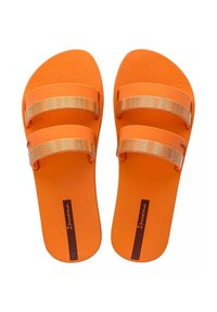 Sandali arancioni con due fasce larghe. Le fasce presentano un motivo ondulato dorato, mentre la suola ha un design testurizzato. Realizzati in materiale di gomma.