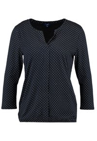 Černá dlouhá tričko s výstřihem do V a bílými puntíky. Má volný střih a měkkou texturu, vhodné pro každodenní nošení.