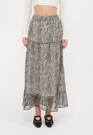 Maxi skirt made of lightweight, sheer fabric with a black and white zebra print, featuring an elastic waistband and ruffled hem.