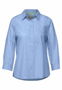 Světle modrá košile na knoflíky s dlouhými rukávy, jednou náprsní kapsou, strukturálním límcem a hladkým povrchem. Obsahuje klasické zapínání na knoflíky.