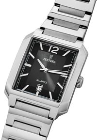 Srebrna nerjaveča jeklena ročna ura s kvadratnim črnim zaslonom, kvartski mehanizem, bele oznake ur in prikaz datuma na položaju 6. ure.