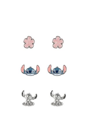 Drei Paare Ohrstecker: rosa fünfblättrige Blumen, blaue Comic-Gesichter, die zwinkern, und glänzende silberne sitzende Comic-Figuren.