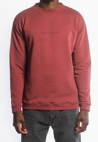 Rode sweatshirt van zachte stof, met een ronde hals en een reliëflogo op de borst. Lange mouwen met ribgebreide manchetten en zoom.
