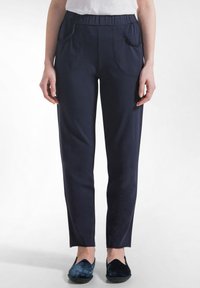 Námořnicky modré kalhoty z měkké látky, s elastickým pasem, dvěma předními kapsami a úzkým, rovně střiženým střihem nohavic.