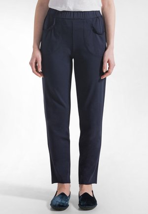 Granatowe spodnie wykonane z miękkiego materiału, z elastycznym pasem, dwoma przednimi kieszeniami oraz wąskimi, prostymi nogawkami.
