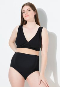 Černý plavecký set obsahující top s v-výstřihem a širokými ramínky a vysokým pasem. Materiál vypadá hladce a pružně, vhodný do vody.