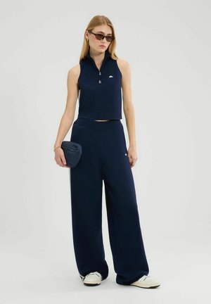 Marineblauwe twee-delige outfit bestaande uit een mouwloze, met rits sluitende cropped top en brede broek. Zachte stof met minimale branding en eenvoudig ontwerp.