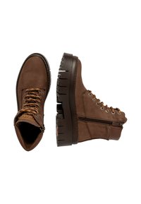 Botas de cuero marrón con un cuello acolchado, parte delantera con cordones y cremallera lateral. Suela de goma gruesa con dibujo para mayor tracción.