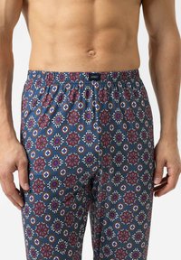 Mannen boxers met patroon in blauw, versierd met rode en witte bloemontwerpen. Elastsiche tailleband; gladde textuur; lengte tot halverwege de dij.