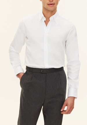 Witte, lange mouwen dress shirt met een button-down kraag, gecombineerd met donkergrijze op maat gemaakte broek, met voorplooien en zijzakken.