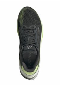 Scarpa sportiva nera e verde con tomaia in rete, lacci testurizzati e marchio stampato. Presenta una suola ammortizzata in bianco e grigio.