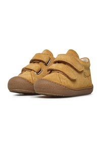 Scarpe scamosciate tan con due strap in velcro, suola in gomma texturizzata, forma arrotondata e dettagli di cucitura. Adatte per un abbigliamento casual.