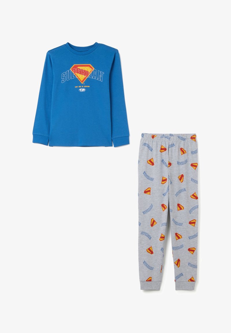 Blauwe longsleeve top en grijze broek set met herhaalde rode en gele Superman-logo's en tekstpatronen.