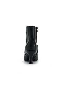 Schwarze Leder-Stiefelette mit einem Reißverschluss hinten, schmalem Absatz, glatter Textur und tailliertem Design, das eine elegante Silhouette präsentiert.