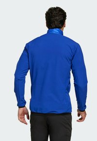 Blauwe sportjacket met lange mouwen, elastische manchetten en een contrasterende kraag. Gemaakt van een gladde, lichte stof voor actieve gebruik.