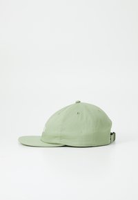 Casquette en coton verte avec une visière courbée, dotée de détails brodés à l'avant, d'une sangle ajustable à l'arrière et de trous d'aération sur le dessus.