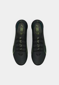 Une paire de chaussures de course Puma ultra noires avec des accents et des lacets jaune néon, vue de dessus sur un fond blanc.