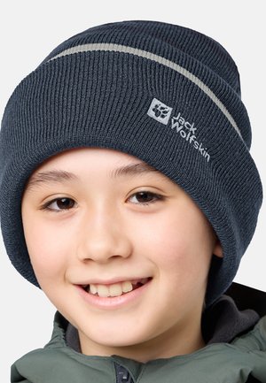 Dunkelblau gestrickte Mütze mit hellgrauen Streifen und Jack Wolfskin-Logo. Weicher Stoff und enganliegende Passform, entworfen für Wärme und Komfort.