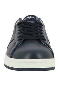 Baskets en cuir bleu marine avec une semelle en caoutchouc blanche, bout arrondi, design à lacets, et accents texturés sur les côtés. Nom de la marque visible sur la languette.