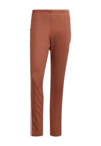 Bruna sweatpants med slim fit, med en elastisk midjeband, sidostråk och en liten vit logotyp på vänster sida. Slät textur.