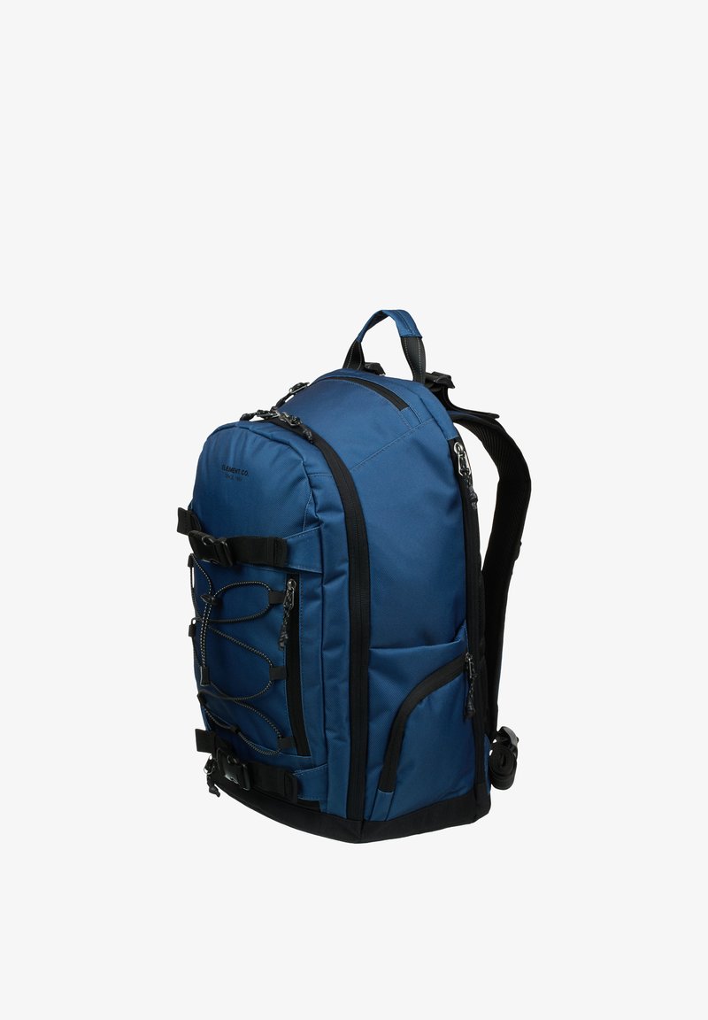 Blå ryggsekk i stoff med elegant design, svarte detaljer, justerbare stropper, flere rom og bungee-snorer foran.