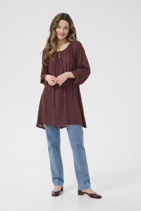Tunique bordeaux avec un col rond, des manches trois-quarts et une coupe décontractée, associée à un jean droit bleu clair et des ballerines marron.