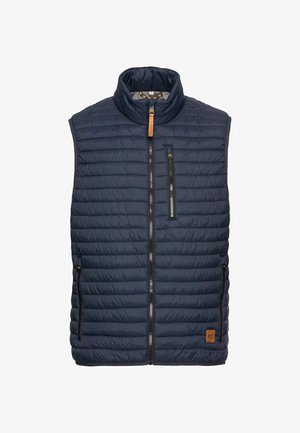 Granatowa kamizelka puchowa z pionowym wzorem pikowania, wysoka stójka, zamek błyskawiczny z przodu oraz dwie boczne kieszenie. Posiada brązowy skórzany akcent z logo.